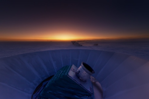 The BICEP2 telescope at twilight, which occurs only twice a year at the South Pole. The MAPO observatory (home of the Keck Array telescope) and the South Pole station can be seen in the background. (Photo credit: Steffen Richter, Harvard University)